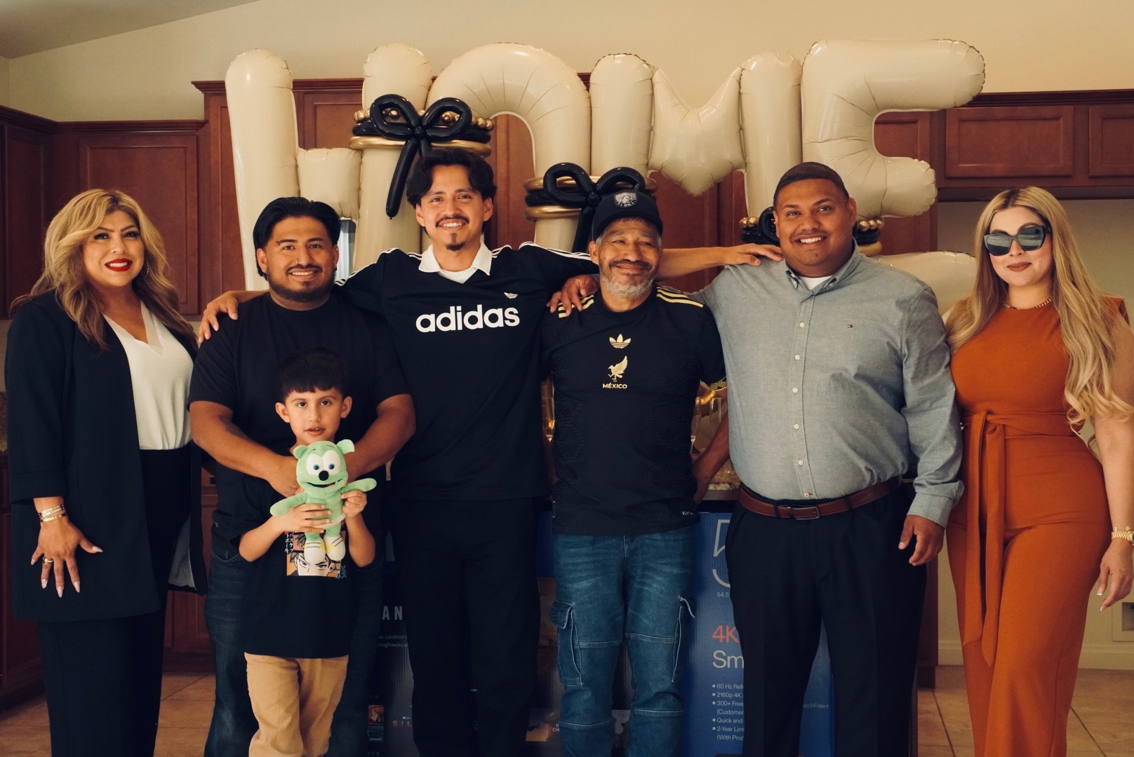 Family celebrating a new home purchase with HOME balloons